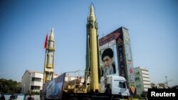 FILE - A display featuring missiles and a portrait of Iran's Supreme Leader Ayatollah Ali Khamenei is seen at Baharestan Square in Tehran, Iran, Sept. 27, 2017.