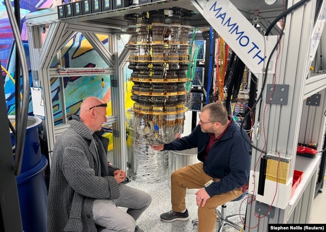 Google Quantum AI's Hartmut Neven (L) and Anthony Megrant (R) examine a cryostat refrigerator for cooling quantum computing chips at Google's Quantum AI lab in Santa Barbara, California, U.S. November 25, 2024. (REUTERS/Stephen Nellis)