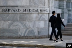 Pedestrians walk towards the Harvard Medical School, August 18, 2022, in Boston, Massachusetts.