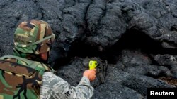 Un guardia nacional toma la temperatura de la lava en Puna, cerca del pueblo de Pahoa, Hawái.