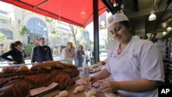 Menepuk-nepuk, membentuk, dan memanggang adonan roti untuk membuat roti khas bagi pasar-pasar swalayan kelas atas dan restoran-restoran bergengsi di New York adalah salah satu pelajaran di toko roti Hot Bread Kitchen yang diberikan kepada perempuan-perempuan imigran yang ingin berkarir menjadi pembuat roti (foto: Dok).