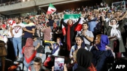 Para perempuan Iran berbaur dengan para penonton laki-laki, memberi semangat tim nasional mereka saat menyaksikan siaran langsung laga penyisihan Grup B Piala Dunia 2018 antara Iran dan Spanyol di Stadion Azadi, Teheran, 20 Juni 218.