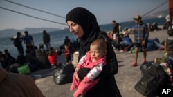 FILE - Montaha, 16, from Aleppo, Syria, walks with her two months daughter Batour after their arrival at the port of Elefsina, near Athens, Oct. 22, 2019.