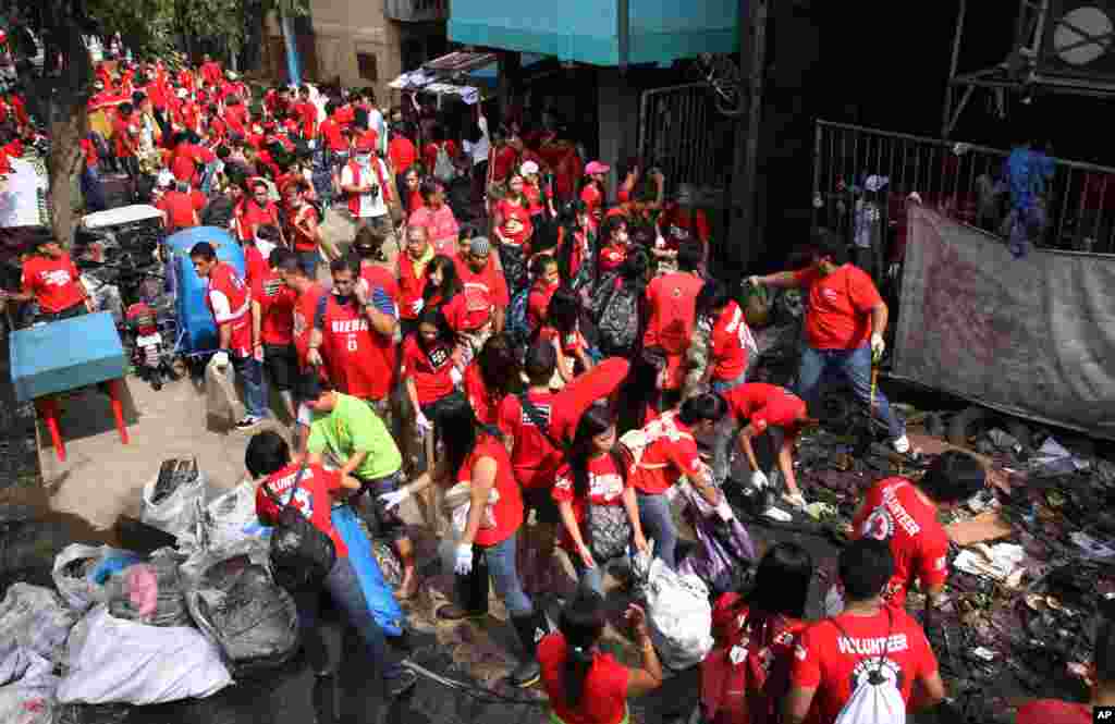 Red Cross volunteers gather to clean an area that was hardly hit by floods in suburban Quezon city, north of Manila, Philippines, August 12, 2012.