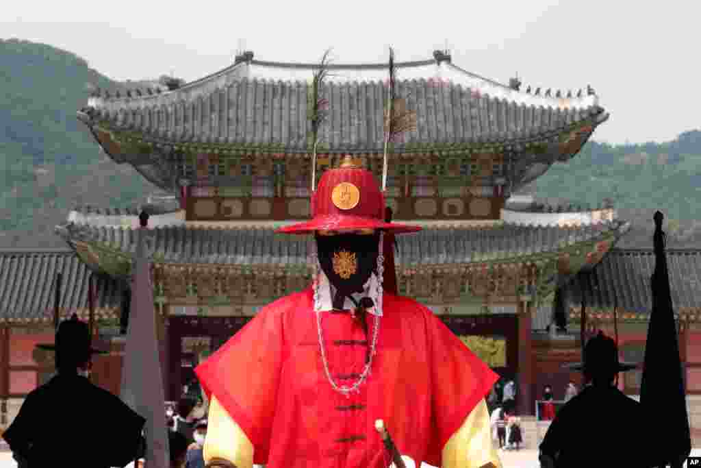 A South Korean Imperial guard waring a face mask stands during a reenactment of the Royal Guards Changing Ceremony, at Gyeongbok Palace in Seoul.