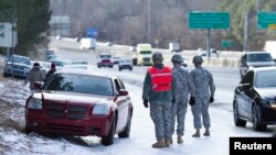 Miembros de la Guardia Nacional ayudan a sacar un auto varado en una carretera de Atlanta.