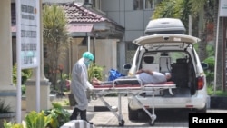 Petugas medis membawa pasien yang diduga terkena virus corona di rumah sakit Adam Malik Haji di Medan, Sumatera Utara, 18 Maret 2020. (Foto: Antara Foto / Septianda Perdana via REUTERS)