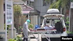 Petugas memindahkan pasien yang diduga terjangkit virus corona ke RS H. Adam Malik di Medan, Sumatera Utara, 18 Maret 2020. 