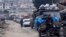 FILE - Syrians drive through the city of al-Mastouma, in Idlib province, as they flee a government offensive, Jan. 28, 2020.