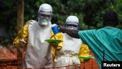 FILE - Medical staff working with Medecins Sans Frontieres (Doctors Without Borders) prepare to take food to patients in the isolation area of an Ebola treatment center in Sierra Leone's Kailahun district, July 20, 2014.