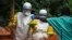 FILE - Medical staff working with Medecins Sans Frontieres (Doctors Without Borders) prepare to take food to patients in the isolation area of an Ebola treatment center in Sierra Leone's Kailahun district, July 20, 2014.