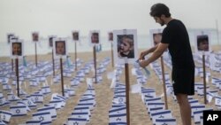 FILE - Israeli flags and photos of Israeli children are displayed on Copacabana beach by the NGO "Rio de Paz" in memory of the victims of the Israeli-Hamas war in Rio de Janeiro, Brazil, November 7, 2023.