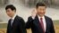 New Politburo Standing Committee member Wang Huning (L) walks past China's President Xi Jinping as they and other new Politburo Standing Committee members meet with the press at the Great Hall of the People in Beijing, China October 25, 2017.