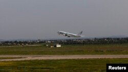 A plane is seen taking off as flights resume at the airport in Tripoli, Libya, March 21, 2014. 