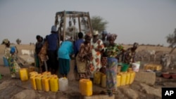 Djiba Ba charge 15 jerrycans d'eau sur une charrette tirée par un âne pour la ramener dans sa famille et ses animaux, dans le village de Mbelone dans la région de Matam au nord-est du Sénégal, le 1er mai 2012