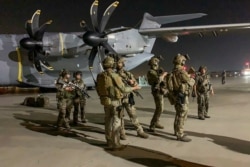 French Special Forces soldiers stand guard near a military plane at airport in Kabul on August 17, 2021, as they arrive to evacuate French and Afghan nationals.