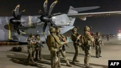 French Special Forces soldiers stand guard near a military plane at airport in Kabul on August 17, 2021, as they arrive to evacuate French and Afghan nationals.