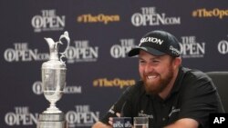 Ireland's Shane Lowry smiles as he sits next to the Claret Jug trophy at a press conference after winning the British Open Golf Championships, at Royal Portrush in Northern Ireland, July 21, 2019.