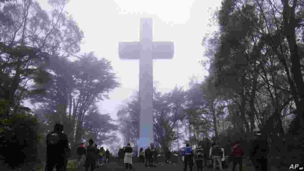 미국 샌프란시스코 마운트 데이비드슨 (Mount Davidson)에서 부활절을 맞아 예정됐던 예배가 &#39;자택 대기령&#39;으로 취소된 가운데 기독교 신자들이 십자가 앞에 모여 있다.