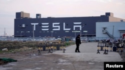 FILE - A Tesla sign is seen on the Shanghai Gigafactory of the U.S. electric car maker before a delivery ceremony in Shanghai, China January 7, 2020. (REUTERS/Aly Song/File Photo)