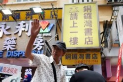 Bookseller Lam Wing-kee waves to supporters outside his Causeway Bay Books bookstore before taking part in a protest march in Hong Kong, June 18, 2016.