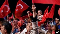 2016年7月31日土耳其总统埃尔多安的支持者在伊斯坦布尔市中心塔克西姆广场的反政变集会上挥舞旗帜。