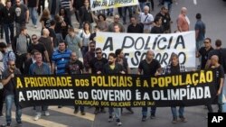 Civil police demand better labor conditions as they carry a banner that reads in Portuguese "The priority of the police is the people, the priority of the government is the Olympics" in Rio de Janeiro, Brazil, June 27, 2016.