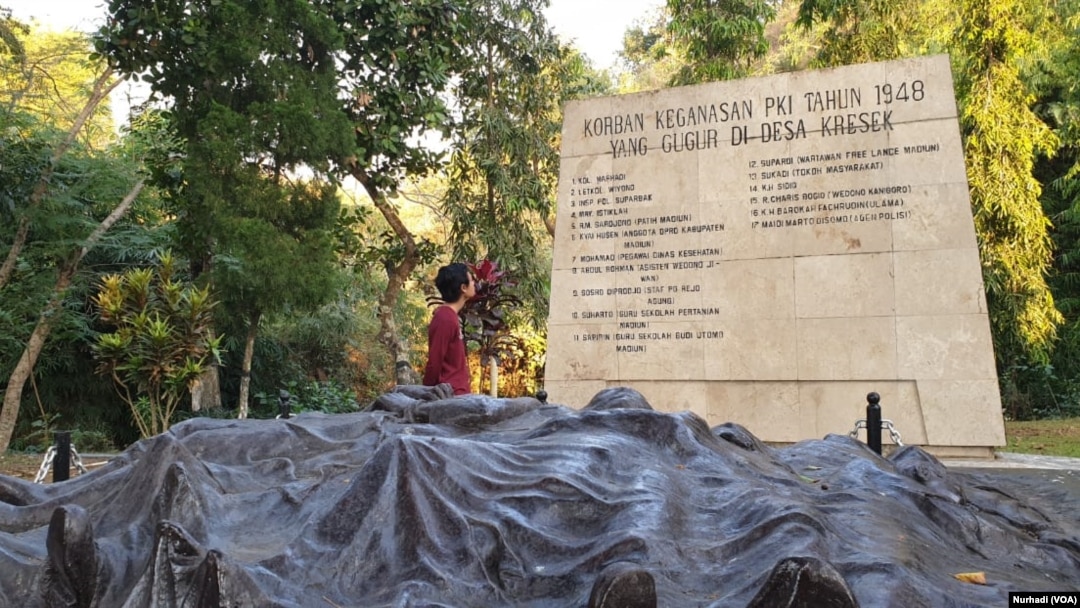 Seorang wisatawan membaca nama-nama korban kekejama n PKI di Monumen Kresek, Madiun. (Foto:VOA/ Nurhadi)