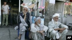 FILE - Former soldiers wait outside a pension office to open in Kabul, Afghanistan, Aug. 26, 2006. 