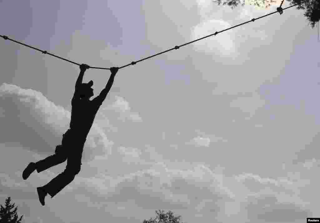 A Free Syrian Army fighter exercises on a rope during a training session at an FSA camp in the countryside of Idlib, October 23