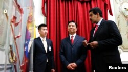 El presidente de Venezuela Nicolás Maduro le muestra al vice presidente de China Li Yuanchao la espada del héroe nacional Simón Bolívar.
