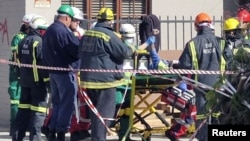 Rescue workers carry a man who survived 118 hours after a building collapse in George