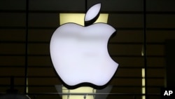 ARCHIVO - El logo de Apple se ve iluminado en una tienda en el centro de Múnich, Alemania, el 16 de diciembre de 2020.
