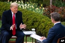 President Donald Trump talks with host Bill Hemmer during a Fox News virtual town hall with members of the coronavirus task force, in the Rose Garden at the White House, March 24, 2020, in Washington.