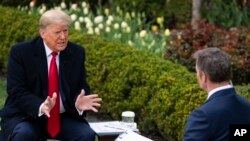 President Donald Trump talks with host Bill Hemmer during a Fox News virtual town hall with members of the coronavirus task force, in the Rose Garden at the White House, March 24, 2020, in Washington.