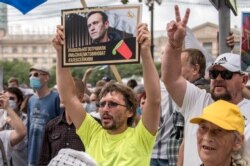 22일 러시아 하바로브스크에서 열린 시위 참가자가 야권 지도자 "#나발니는 독극물 공격을 받았다 #우리는 누가 비난 받아야 하는 지 안다 #나발니는 살아야 한다"는 내용의 포스터를 들고 있다.