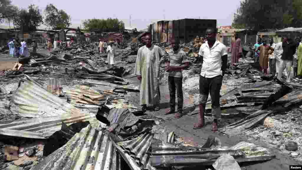 People gather around the ruins of the burnt Bama Market, which was destroyed by gunmen in last Thursday's attack, in Maiduguri, northeast Nigeria April 29, 2013.