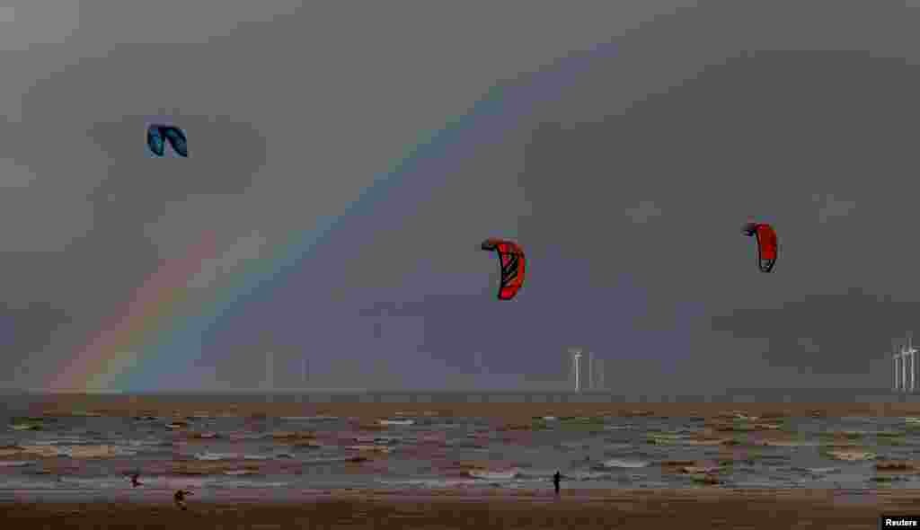 Kite surfers are pictured in front of the Burbo Bank offshore wind farm near New Brighton, Britain.