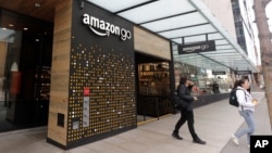 Para pelanggan keluar dari toko Amazon Go di Seattle di mana pembeli bisa melakukan pembayaran melalui piranti pemindai telapak tangan, 4 Maret 2020. 