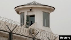 FILE - A guard stands in a watchtower in Kashgar, Xinjiang Uyghur Autonomous Region, China, May 3, 2021. 