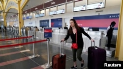 Una pasajera deja un mostrador de Delta Airlines después de registrarse para un vuelo en el aeropuerto Nacional Reagan en Washington, EE.UU. el 29 de abril de 2020. 