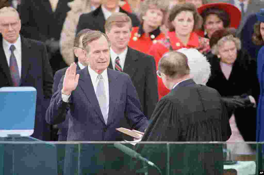 George H. W. Bush levanta la mano mientras toma el juramento de su cargo como presidente n&#250;mero 41 de Estados Unidos, el 20 de enero de 1989. 