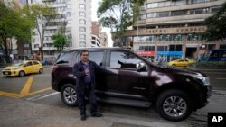 Alberto Yepes, un destacado activista de derechos humanos, habla junto a la camioneta asignada por el gobierno durante una entrevista en Bogotá, Colombia, el viernes 22 de julio de 2022.