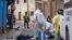 Health workers disinfect the body of a street vendor who was found dead by his neighbors in the Cerro San Miguel neighborhood of Cochabamba, Bolivia, July 25, 2020.