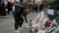 People lay flowers as part of a memorial to victims a day after more than 120 people were killed in a series of attacks in Paris, Nov. 14, 2015.