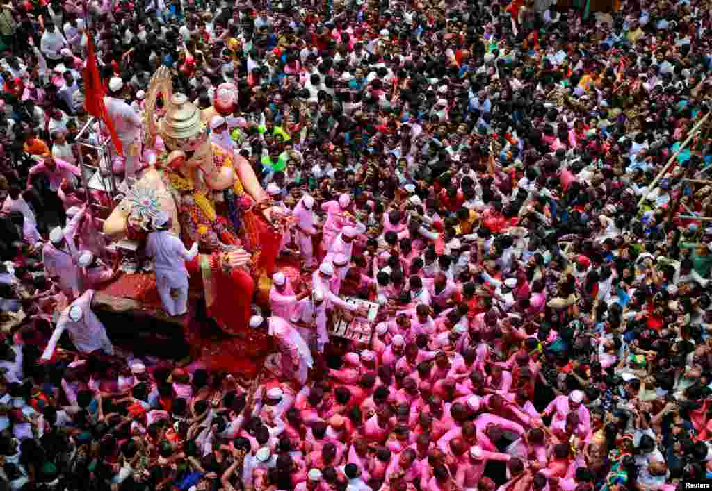 Devotees carry an idol of Hindu god Ganesh, the deity of prosperity, during a procession on the last day of the Ganesh Chaturthi festival, before immersing the idol into the Arabian sea, in Mumbai, India.