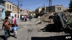 FILE - People walk in a street of Silvan district in Diyarbakir after clashes between Turkish army and Kurdish rebels, Aug. 19, 2015.