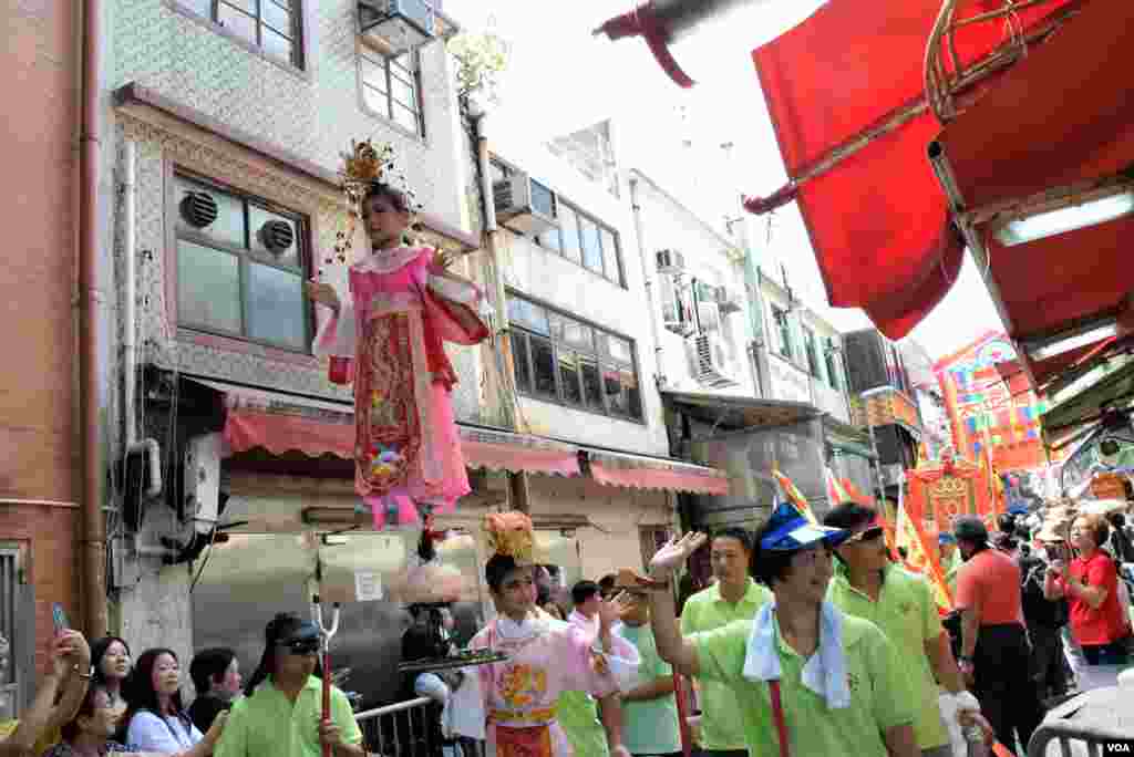 長洲太平清醮飄色巡遊的「色芯」在大街小巷中巡遊，向圍觀的人揮手。(美國之音記者湯惠芸拍攝)