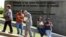 Pedestrians walk past a wall outside the U.S. embassy in Caracas, Venezuela, Oct. 1, 2013.