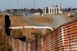 FILE - Prototypes for U.S. President Donald Trump's border wall with Mexico are shown near completion behind the current border fence, in this picture taken from the Mexican side of the border, in Tijuana, Oct. 23, 2017.